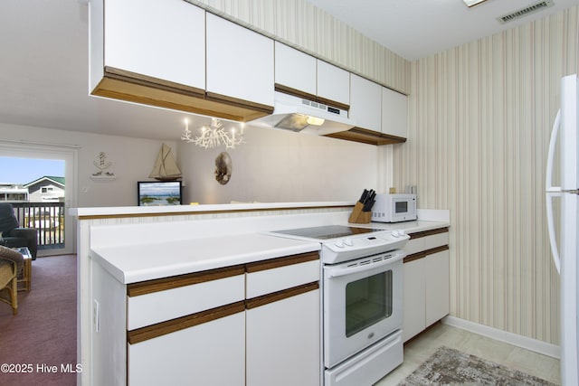 kitchen with wallpapered walls, white appliances, white cabinets, under cabinet range hood, and visible vents