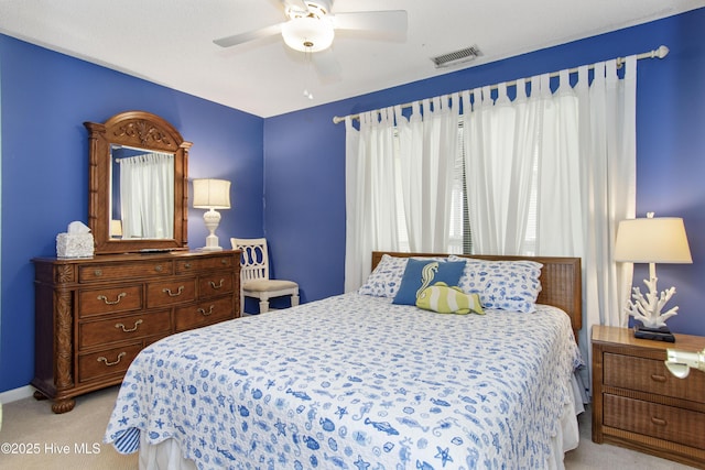 bedroom with visible vents, light colored carpet, and ceiling fan