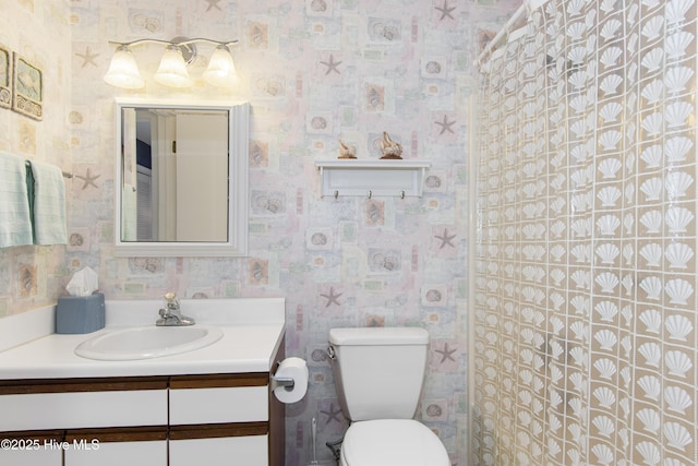 full bathroom featuring toilet, vanity, and wallpapered walls