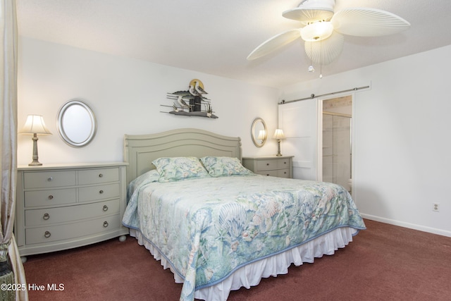 bedroom with ensuite bath, ceiling fan, dark colored carpet, and a barn door