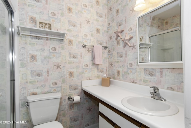 bathroom with a shower stall, vanity, and toilet