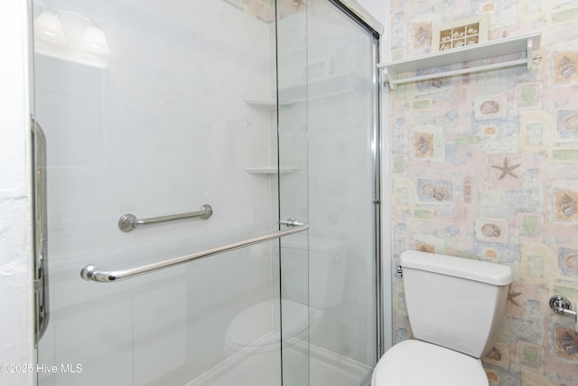 bathroom featuring toilet and a stall shower