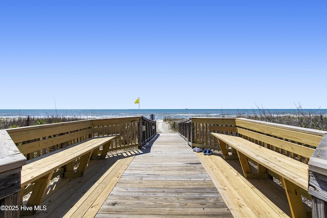 view of community featuring a water view and a beach view