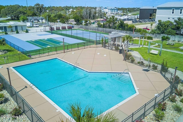 community pool featuring a yard, fence, and a patio