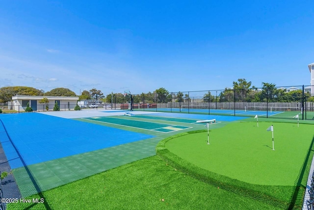 surrounding community with a tennis court, fence, and community basketball court