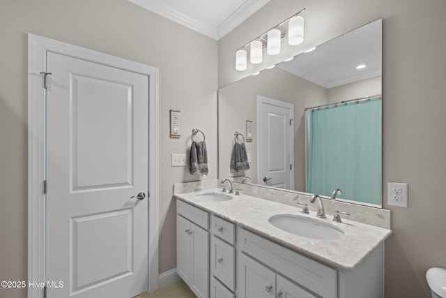 full bathroom featuring double vanity, toilet, crown molding, and a sink