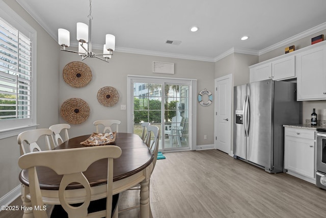 dining room with light wood-style flooring, visible vents, a wealth of natural light, and baseboards