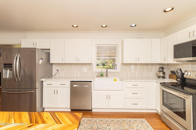 206 Robin Ln, Edenton, NC 27932 - kitchen with appliances with stainless steel finishes, a sink, white cabinets, backsplash, and ornamental molding