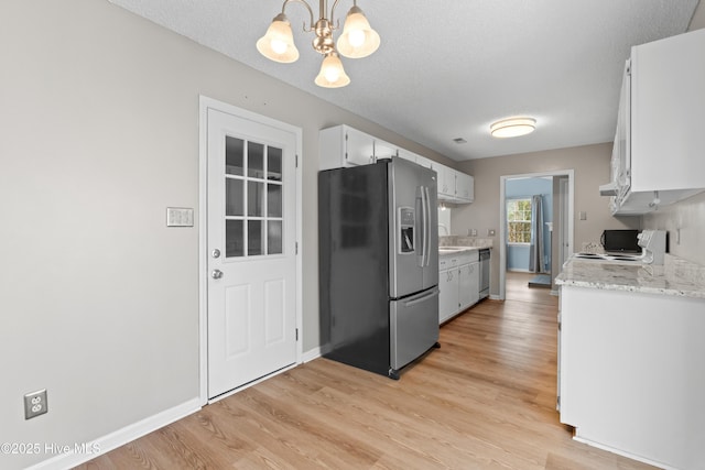 kitchen featuring a notable chandelier, light wood-style floors, a sink, and stainless steel appliances