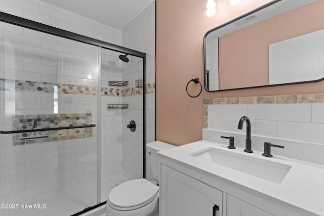 full bath with visible vents, a shower stall, toilet, vanity, and tasteful backsplash