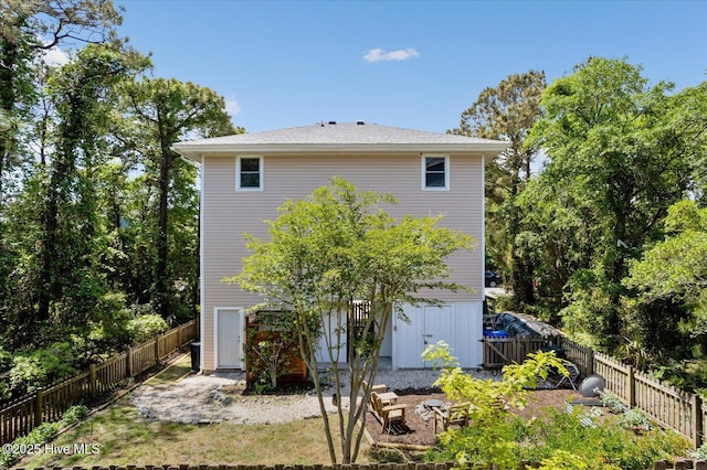 rear view of house with a fenced backyard