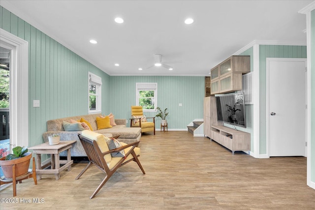 living room featuring ornamental molding, baseboards, recessed lighting, light wood-type flooring, and a ceiling fan