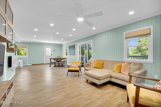 living area with ornamental molding, a ceiling fan, recessed lighting, and light wood-style flooring