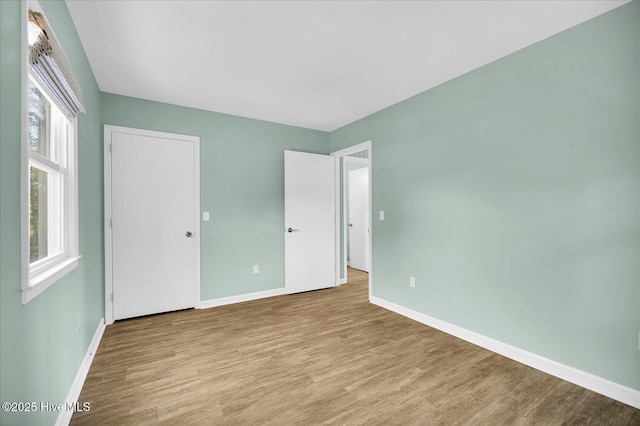 unfurnished bedroom with baseboards and wood finished floors