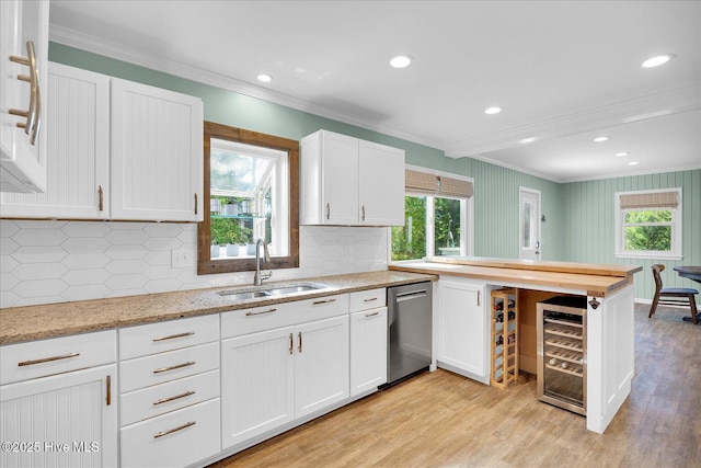 kitchen with stainless steel dishwasher, ornamental molding, beverage cooler, white cabinets, and a sink