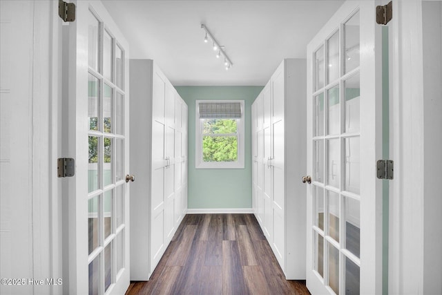 doorway to outside featuring baseboards, french doors, rail lighting, and dark wood-type flooring
