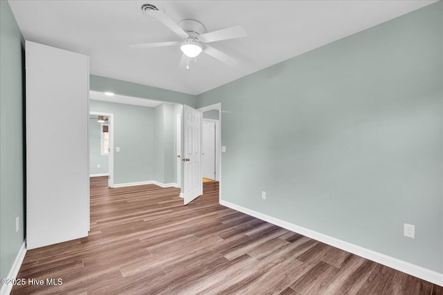 unfurnished room featuring baseboards, ceiling fan, and wood finished floors
