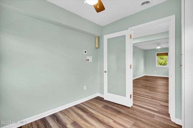 unfurnished room with baseboards, a ceiling fan, wood finished floors, and visible vents