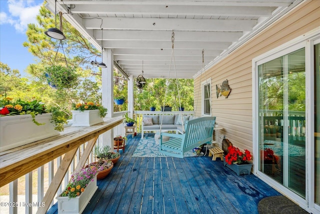 wooden terrace with an outdoor living space
