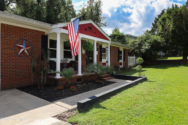 304 Sheffield Rd, Jacksonville, NC 28546 - view of front of house with brick siding, a porch, and a front lawn