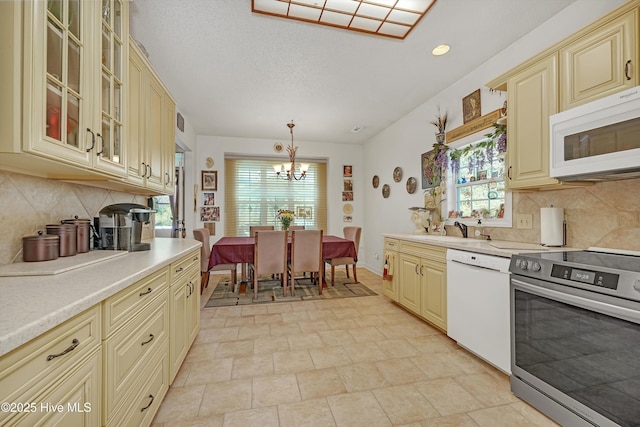 7001 Robert Ruark Dr SE, Southport, NC 28461 - kitchen featuring cream cabinetry, white appliances, a chandelier, light countertops, and recessed lighting