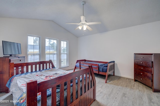 bedroom featuring baseboards, light wood-type flooring, ceiling fan, and lofted ceiling