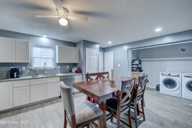 dining area with baseboards, a ceiling fan, a textured ceiling, independent washer and dryer, and light wood-style flooring