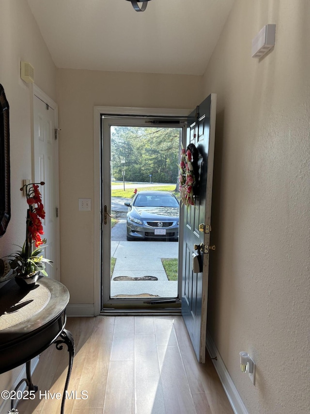 entryway with light wood-style flooring and baseboards