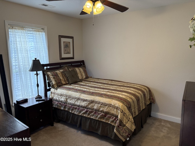 carpeted bedroom featuring visible vents, baseboards, and ceiling fan