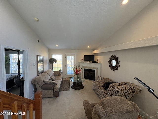 living room with a healthy amount of sunlight, high vaulted ceiling, a fireplace, and recessed lighting