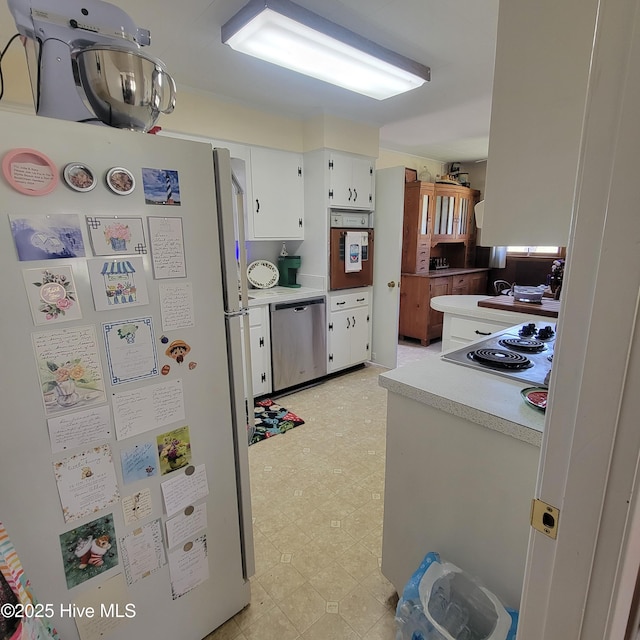 kitchen featuring white cabinetry, light countertops, appliances with stainless steel finishes, and light floors