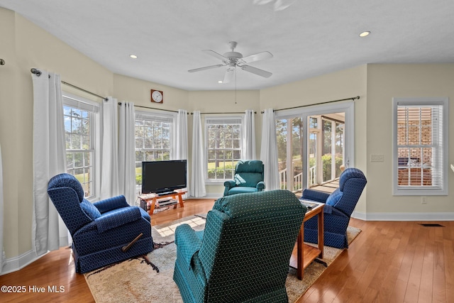 living area with ceiling fan, visible vents, baseboards, wood-type flooring, and recessed lighting