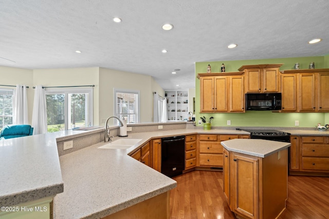 174 Banbridge Dr, West End, NC 27376 - kitchen featuring a sink, a center island, light wood-style floors, and black appliances