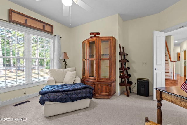 living area with ceiling fan, carpet, stairs, and visible vents