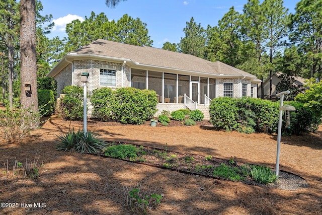 174 Banbridge Dr, West End, NC 27376 - view of front of property featuring roof with shingles, a sunroom, and brick siding