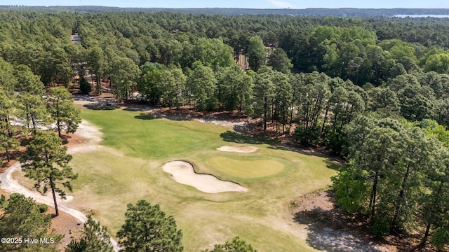 aerial view featuring golf course view and a wooded view