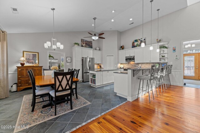 222 Brite Ln, Oriental, NC 28571 - dining room with recessed lighting, dark wood-style flooring, high vaulted ceiling, ceiling fan with notable chandelier, and visible vents
