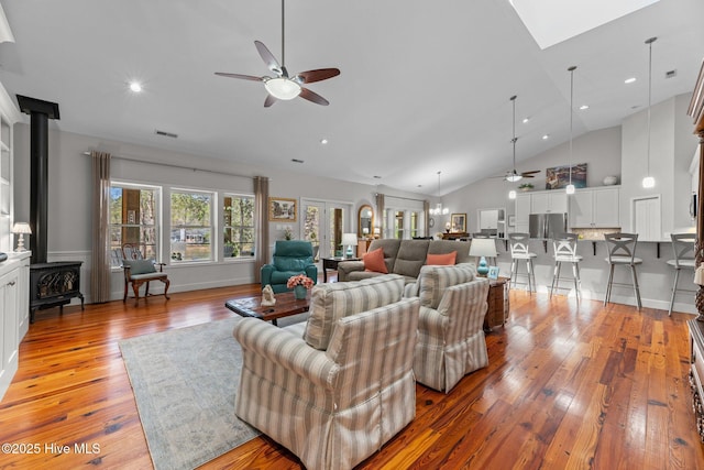 222 Brite Ln, Oriental, NC 28571 - living room featuring ceiling fan, high vaulted ceiling, a wood stove, and light wood finished floors