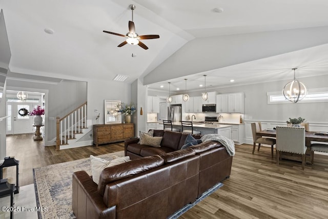 323 Lightning Bug Ln, Holly Ridge, NC 28445 - living room with vaulted ceiling, ceiling fan, stairway, wood finished floors, and a chandelier