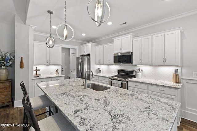 323 Lightning Bug Ln, Holly Ridge, NC 28445 - kitchen featuring appliances with stainless steel finishes, a sink, crown molding, a center island with sink, and tasteful backsplash