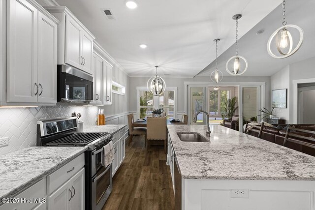 323 Lightning Bug Ln, Holly Ridge, NC 28445 - kitchen featuring stainless steel appliances, a sink, dark wood-style flooring, an island with sink, and light stone countertops