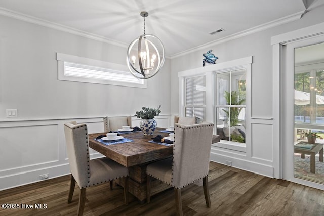 323 Lightning Bug Ln, Holly Ridge, NC 28445 - dining space with a decorative wall, a chandelier, ornamental molding, wood finished floors, and wainscoting