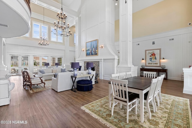 323 Lightning Bug Ln, Holly Ridge, NC 28445 - dining room with a towering ceiling, decorative columns, a chandelier, a decorative wall, and healthy amount of natural light