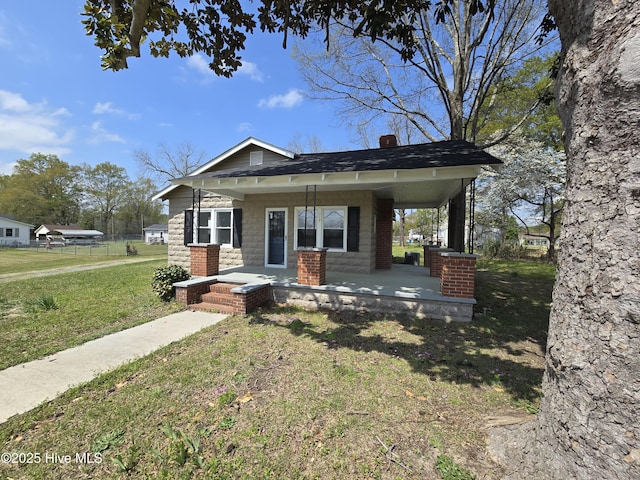 117 Flowers St, Rockingham, NC 28379 - bungalow-style home with a porch, a front yard, and a chimney
