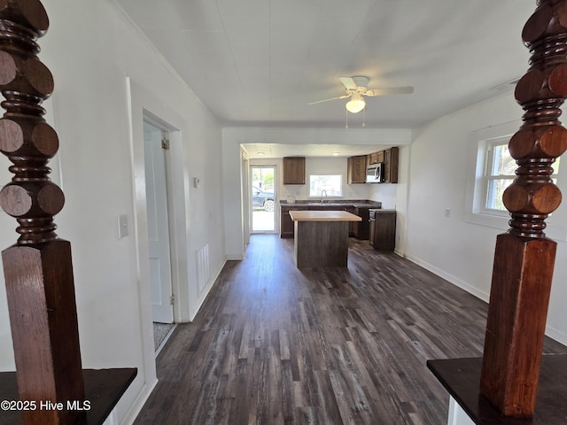 117 Flowers St, Rockingham, NC 28379 - kitchen featuring a sink, a kitchen island, stainless steel microwave, ceiling fan, and dark wood-type flooring