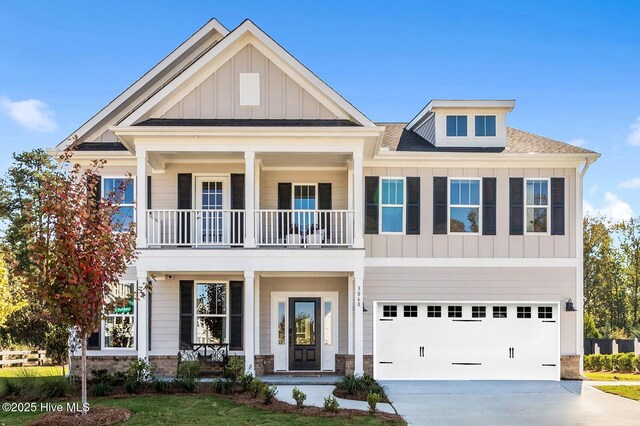 view of front of home featuring driveway, covered porch, an attached garage, and board and batten siding