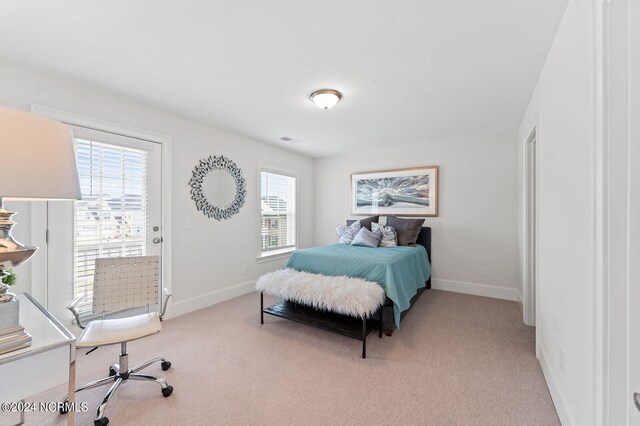 bedroom with baseboards, visible vents, and light carpet