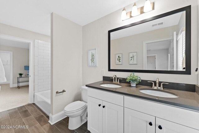 full bath with double vanity, visible vents, toilet, and a sink