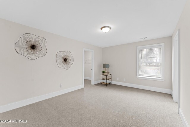 carpeted empty room with baseboards and visible vents