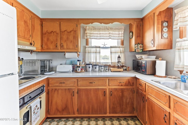 713 Channel Blvd, Topsail Beach, NC 28445 - kitchen featuring light countertops, brown cabinets, under cabinet range hood, and white appliances